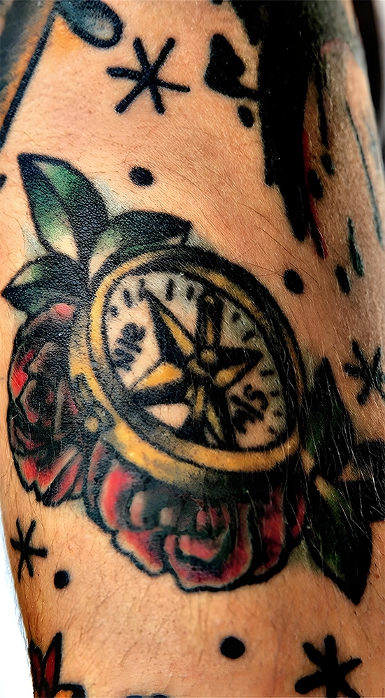 colorful compass tattoo on arm