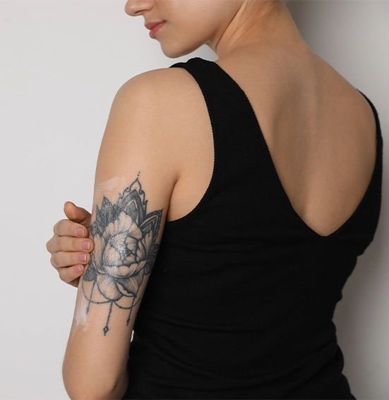 girl-moisturizing-her-black-and-grey-sleeve-tattoo