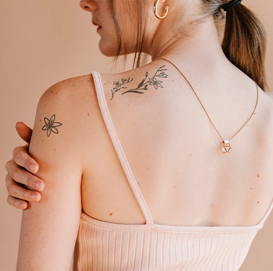 minimalist tattoos on girl shoulder and behind neck