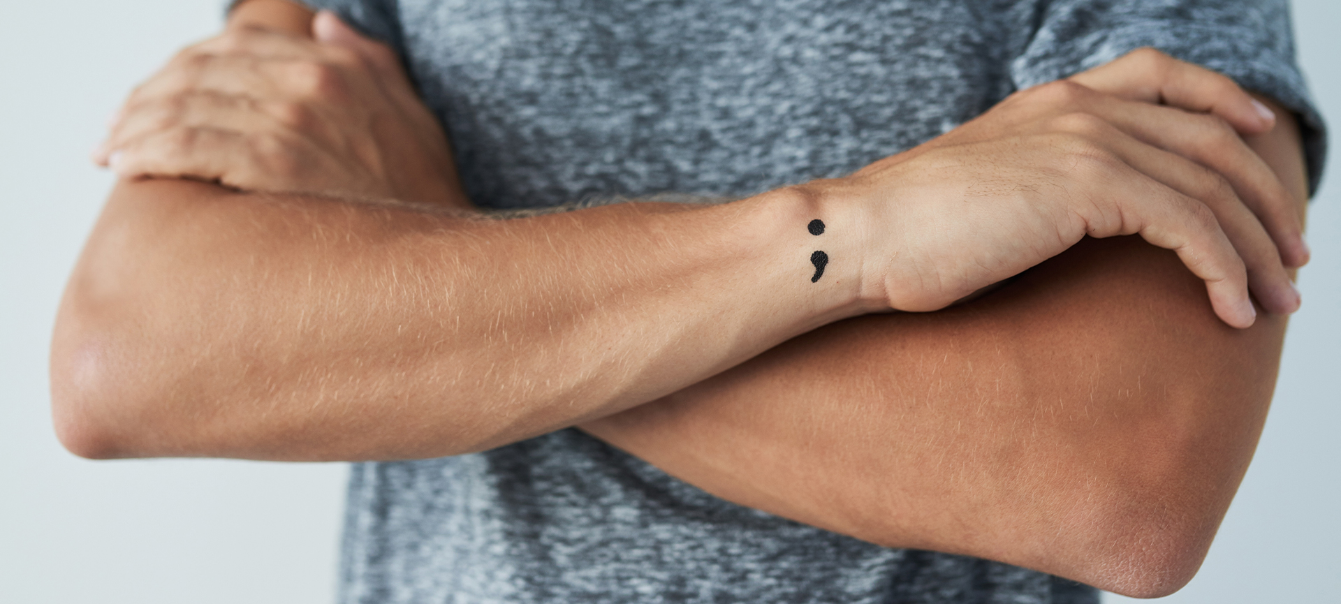 man on his wrist semi colon tattoo